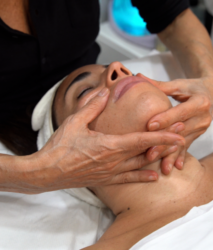 Une spécialiste en esthétique effectue un massage professionnel au visage d'une femme.