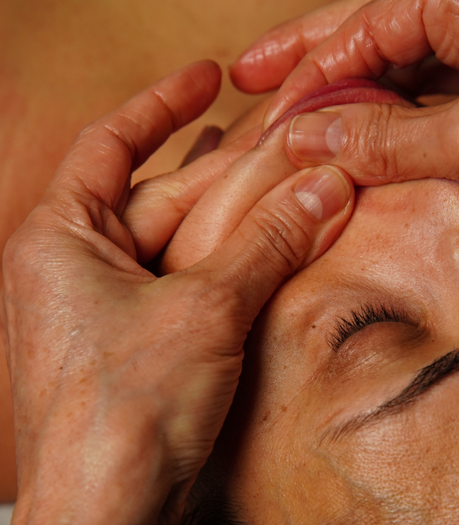 Visage d'une femme massant en appliquant la méthode de massage Kobido.
