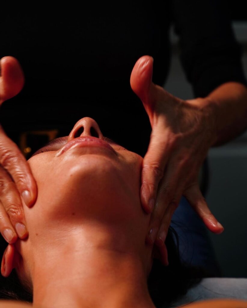 Une masseuse prenant soin d'une cliente lors d'un soin du visage avec ses doigts