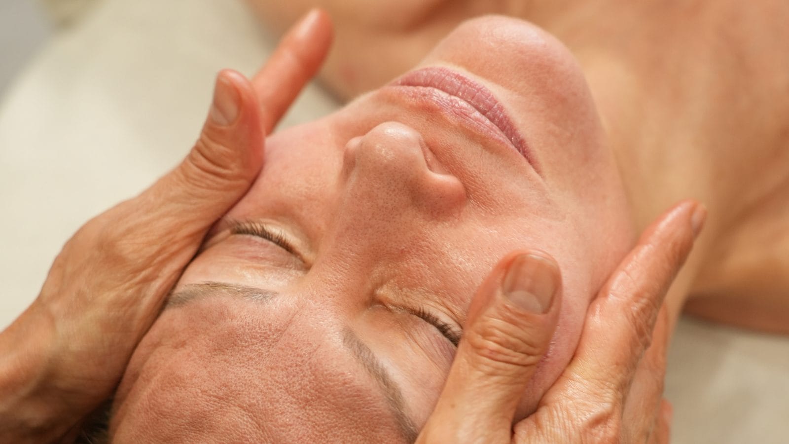 Formation massage Kobido : les deux mains de Ruth Niddam sur le visage d'une cliente